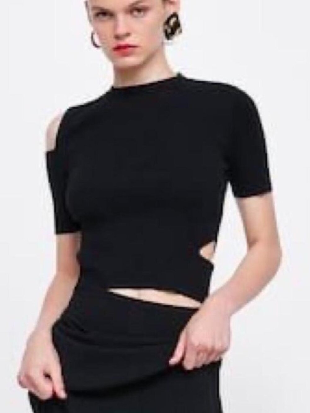 Black knit cut out top with cutouts at the shoulders and waist